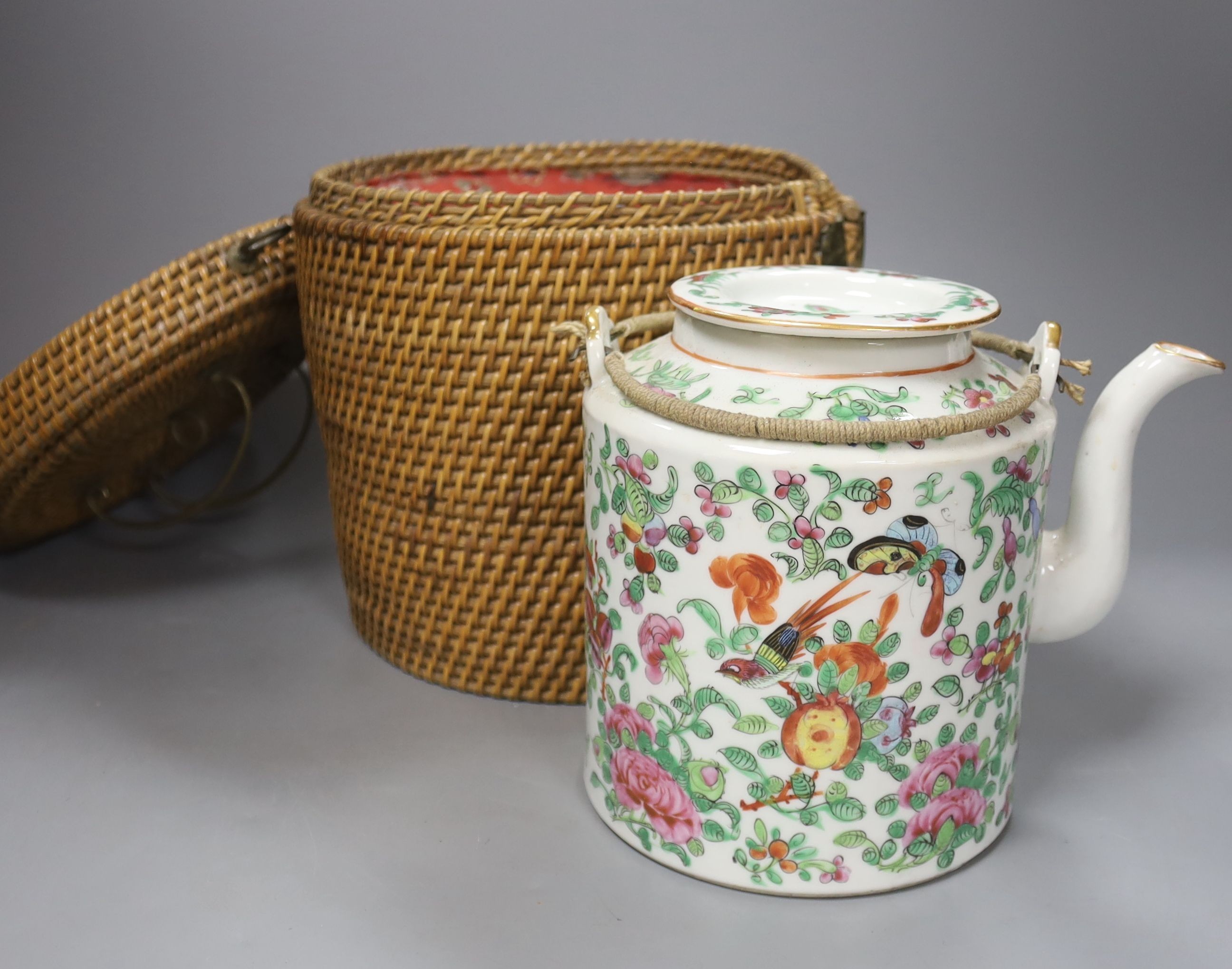 Three late 19th/early 20th century Chinese famille teapots, two in baskets and a similar dish, dish 29.5 cms diameter.